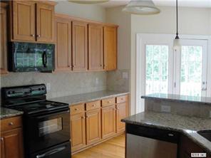 112 Rushing Water Lane Troutman, NC 28166 - Photo 4 of 16 a kitchen with granite countertop a stove sink and cabinets