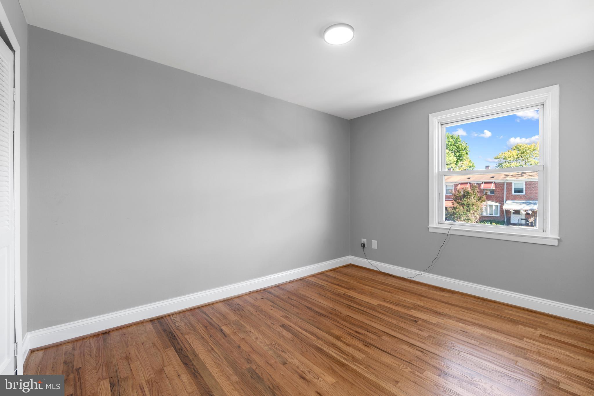 1618 Riverwood Road Baltimore, MD 21221 - Photo 11 of 26 an empty room with wooden floor and window