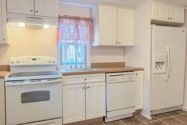 a kitchen with white cabinets and white appliances