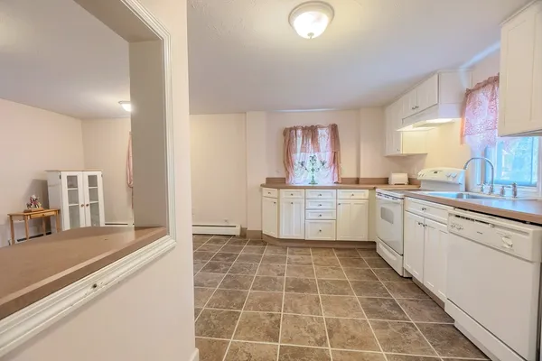 a large white kitchen with a stove a sink dishwasher and a refrigerator