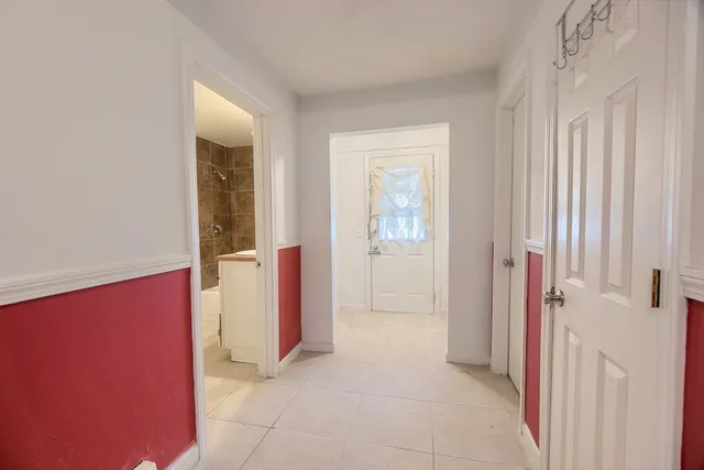 a view of a hallway with closet and a bathroom