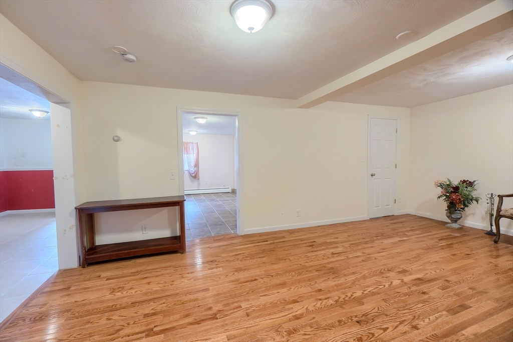 201-203 Stone Street Clinton, MA 01510 - Photo 7 of 42 a view of an empty room with wooden floor and a window