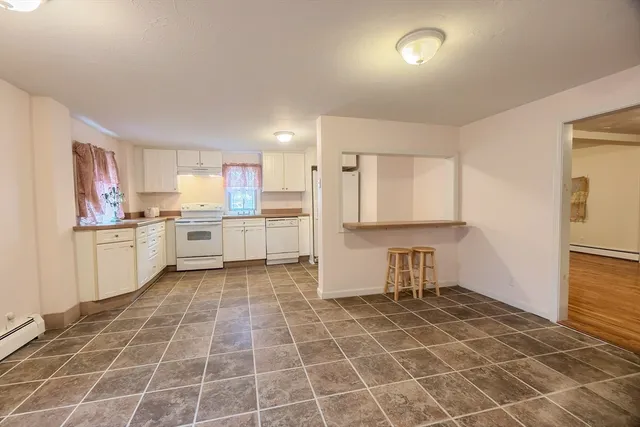 a kitchen with stainless steel appliances a sink a stove a refrigerator cabinets and a window