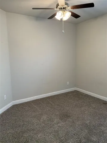a view of an empty room with a chandelier fan