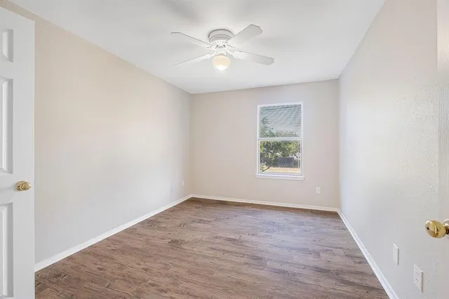 wooden floor in an empty room with a window