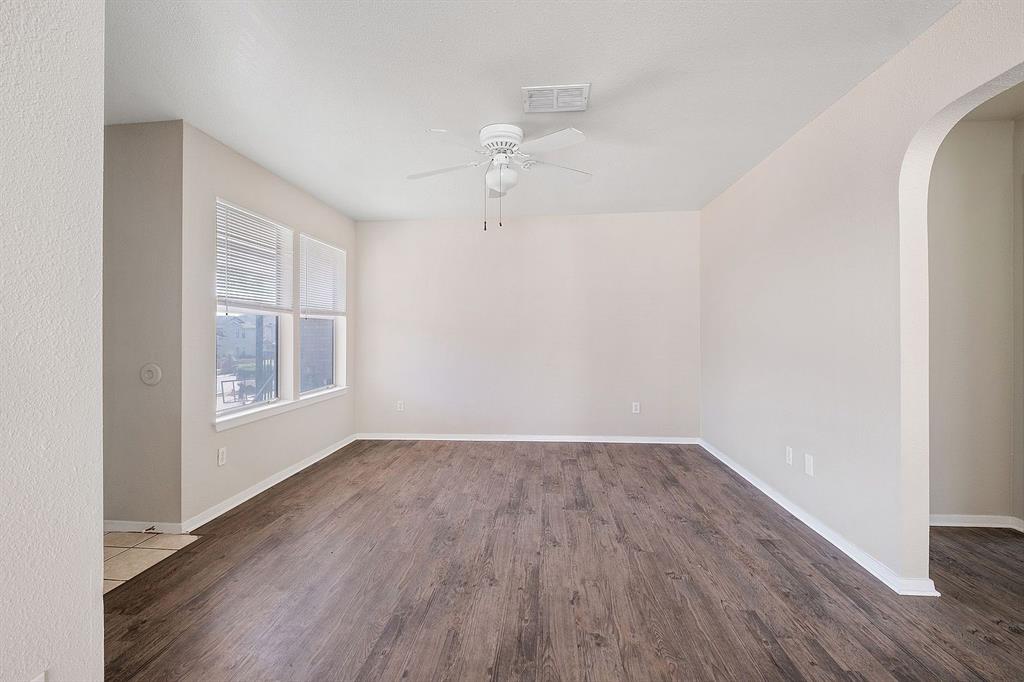 2214 Katy Lane, Unit A Georgetown, TX 78626 - Photo 3 of 15 an empty room with wooden floor chandelier fan and windows