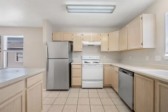 a kitchen with a refrigerator sink and cabinets