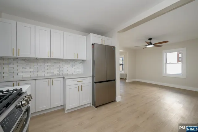 a kitchen with a refrigerator and a stove top oven