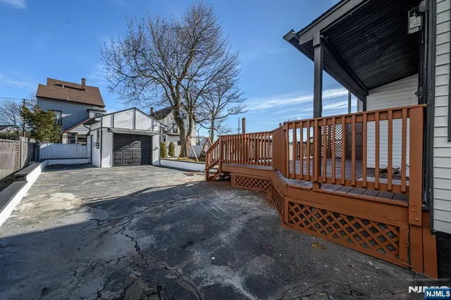 a view of a house with wooden fence next to a yard