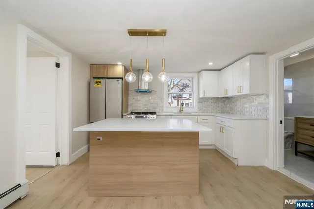a large kitchen with kitchen island a sink stainless steel appliances and cabinets
