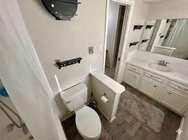 a white toilet sitting next to a bathroom sink and a mirror