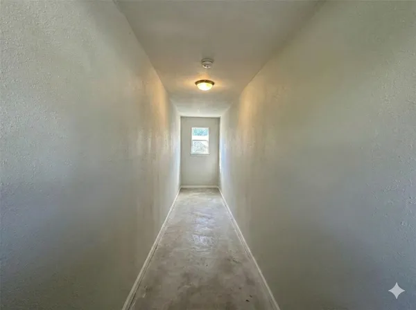 a view of a hallway with wooden floor and a window
