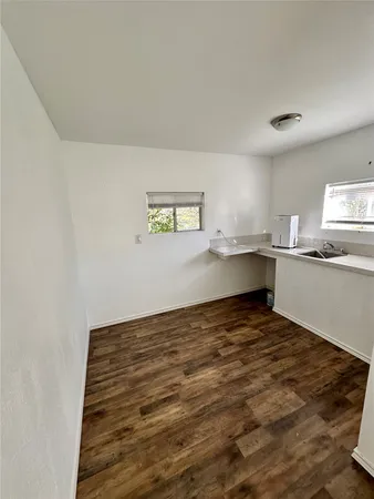 a view of a kitchen with wooden floor and electronic appliances
