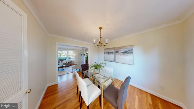 a dining room with wooden floor and white walls