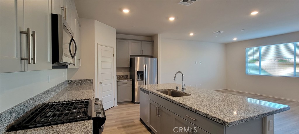 32916 Earlsburn Circle Menifee, CA 92584 - Photo 12 of 34 a kitchen with stainless steel appliances granite countertop a sink stove and refrigerator