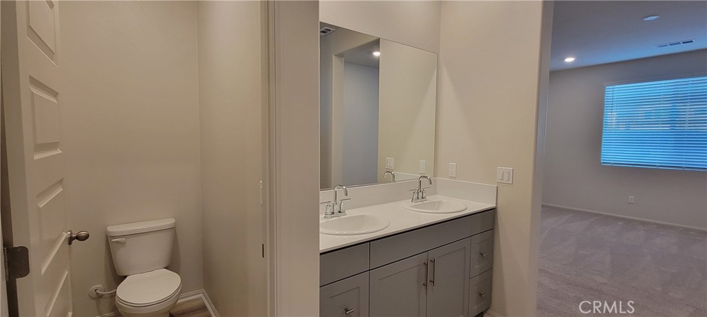 32916 Earlsburn Circle Menifee, CA 92584 - Photo 18 of 34 a bathroom with a sink a toilet a shower and a mirror