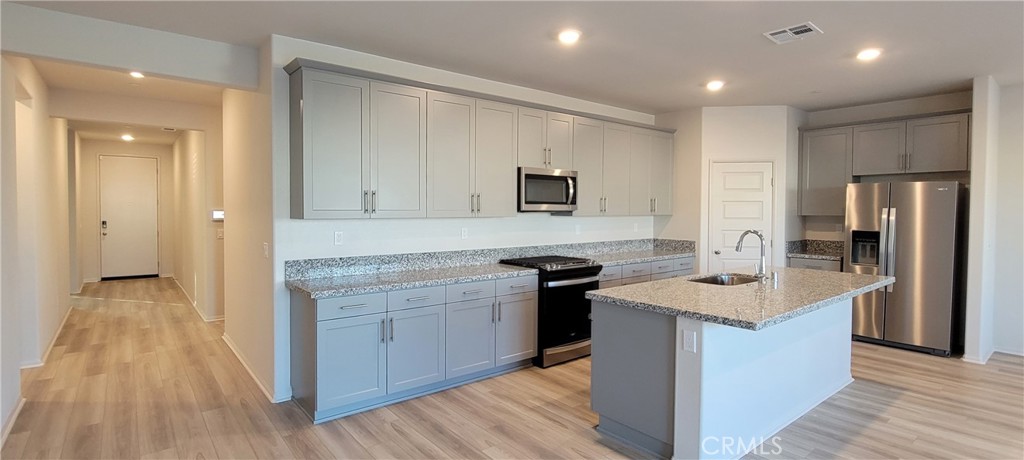 32916 Earlsburn Circle Menifee, CA 92584 - Photo 22 of 34 a kitchen with granite countertop a sink stove and refrigerator