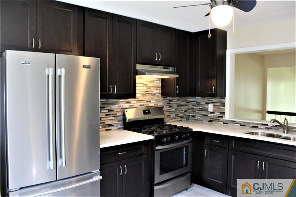 903 Timber Oaks Road, Unit 903 Edison, NJ 08820 - Photo 5 of 34 a kitchen with a sink stove and refrigerator