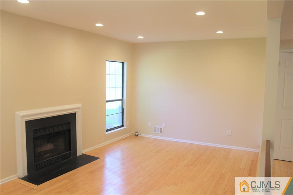 903 Timber Oaks Road, Unit 903 Edison, NJ 08820 - Photo 9 of 34 a view of empty room with a fireplace and wooden floor