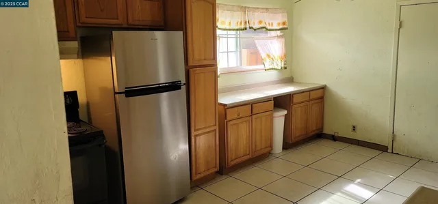 a kitchen with metallic refrigerator and window