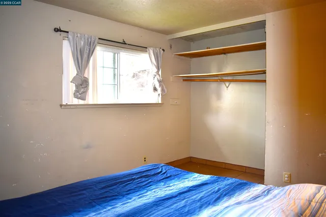 a view of a room with wooden floor and small window