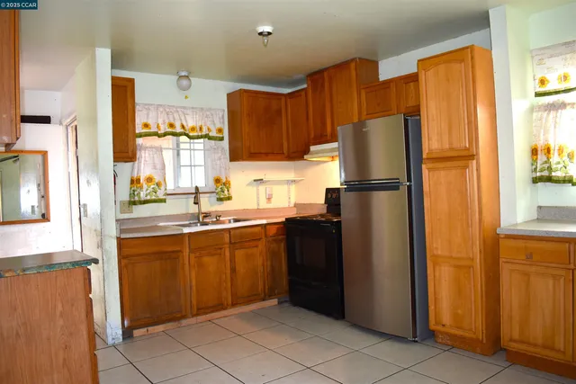 a kitchen with granite countertop a refrigerator and a sink