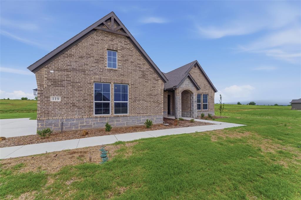 119 Hillview Trail Decatur, TX 76234 - Photo 3 of 30 Brick and stone exterior featuring an arched entry, gabled rooflines, and multiple window styles