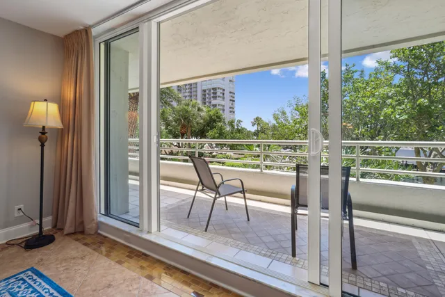 a view of a room with a large window and wooden floor