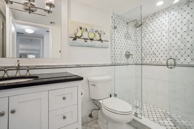 a bathroom with a granite countertop sink a toilet and a mirror