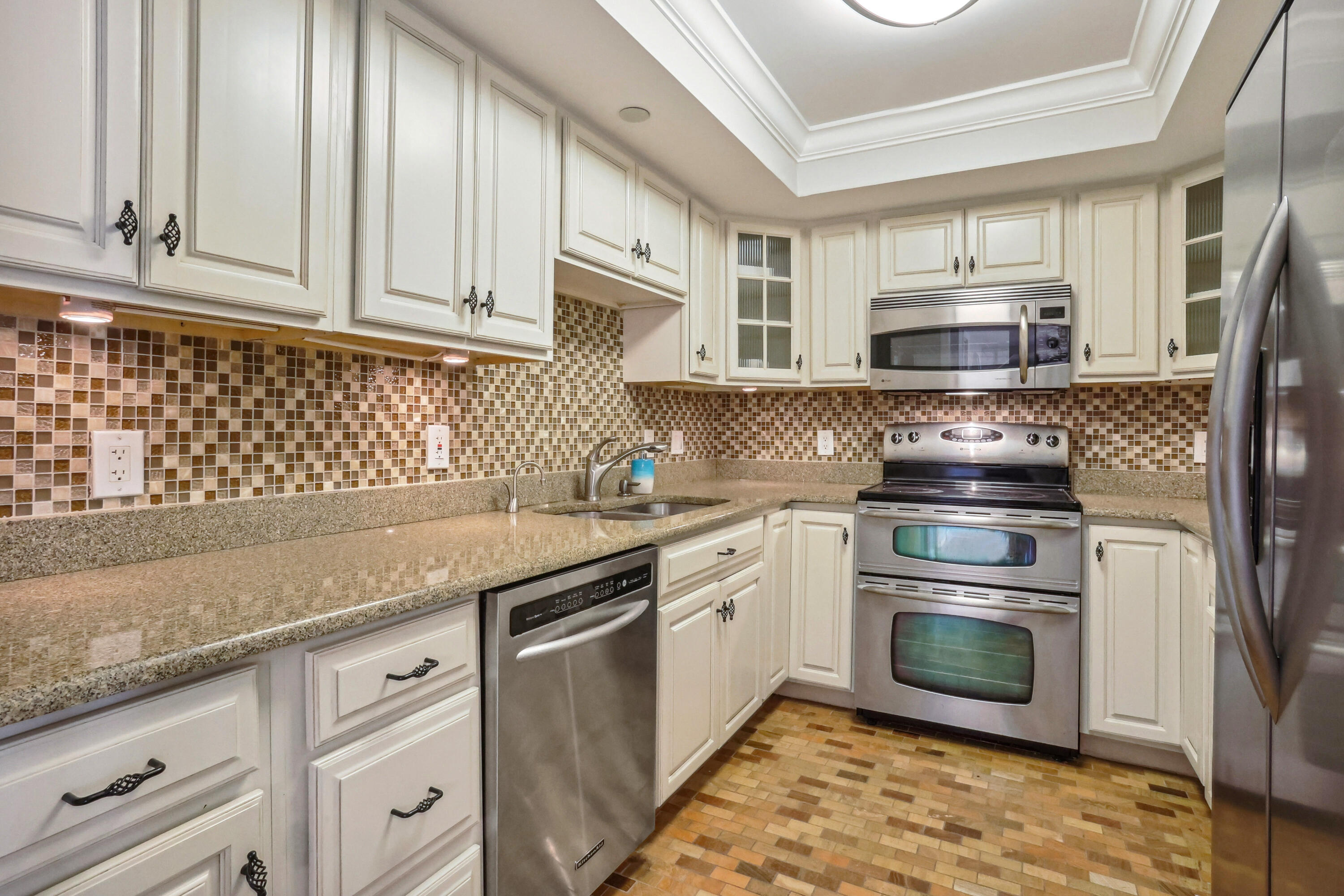 4201 North Ocean Boulevard, Unit 208 Boca Raton, FL 33431 - Photo 10 of 38 a kitchen with stainless steel appliances granite countertop a stove a sink and a microwave