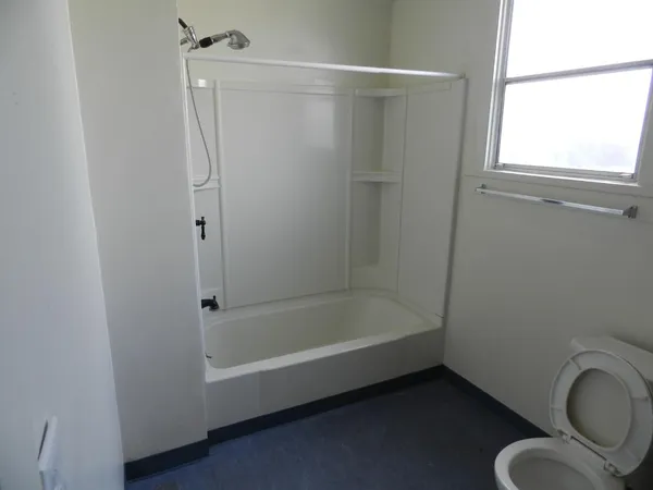 a bathroom with a bathtub a toilet and a shower