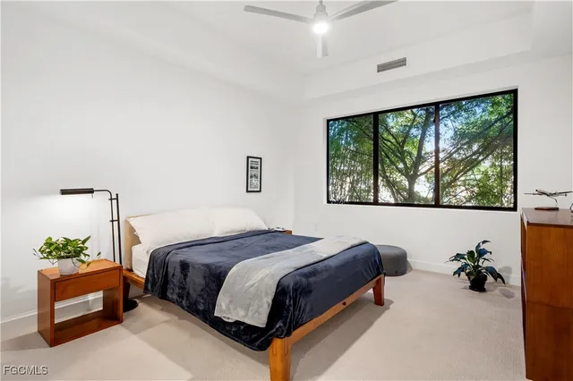 a spacious bedroom with a bed and a large window