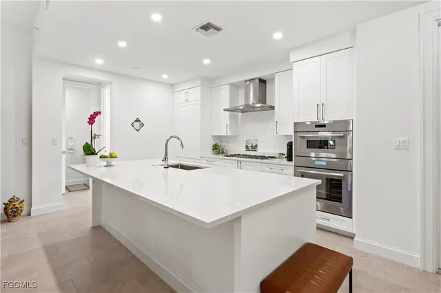 a kitchen with stainless steel appliances kitchen island sink stove and cabinets