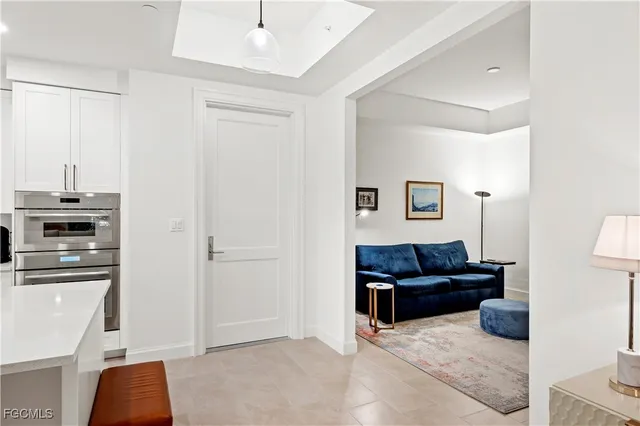 a living room with furniture and a refrigerator
