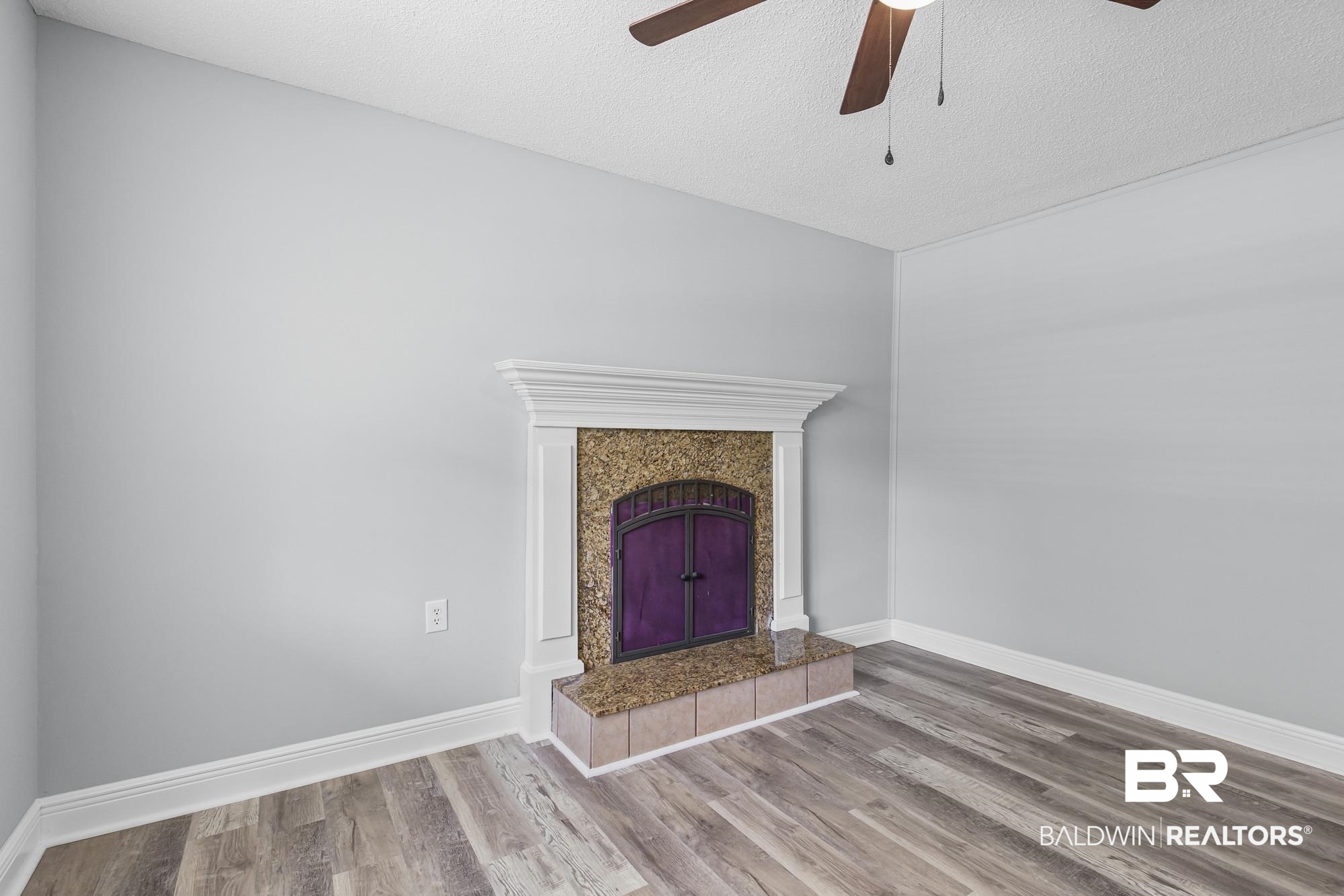 6933 Burbank Court Mobile, AL 36619 - Photo 10 of 25 Fireplace featuring a white mantelpiece, textured stone surround, and a tiled hearth