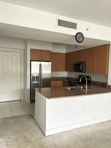 a view of a refrigerator a sink and dishwasher
