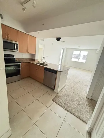 a large kitchen with a stove a sink and a microwave