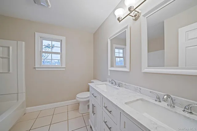 a bathroom with a granite countertop sink mirror vanity and toilet