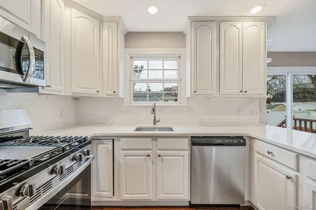a kitchen with stainless steel appliances granite countertop a sink a stove and a microwave