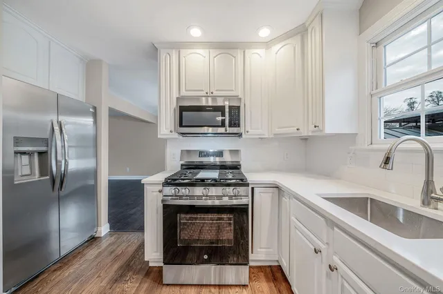 a kitchen with stainless steel appliances granite countertop a stove a refrigerator and a sink