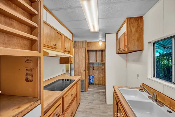 a kitchen that has a kitchen island wooden cabinets and a refrigerator