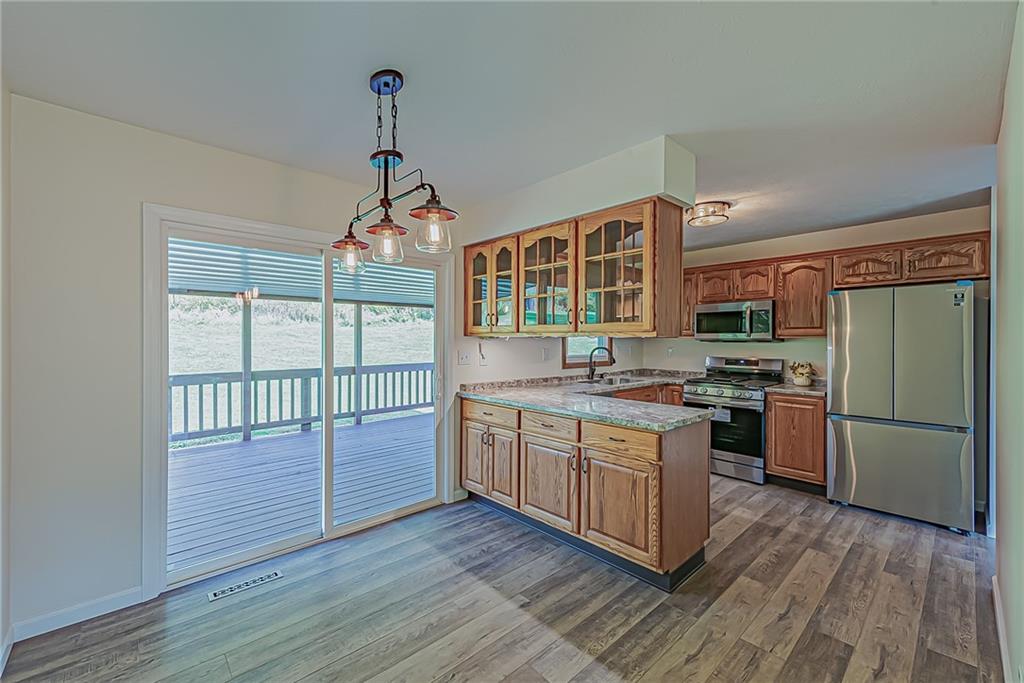 510 Crooks Road Home, PA 15747 - Photo 3 of 20 a kitchen with kitchen island wooden floors appliances and cabinets