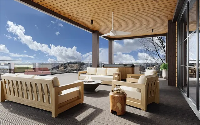 a view of a patio with couches chairs potted plants and wooden floor