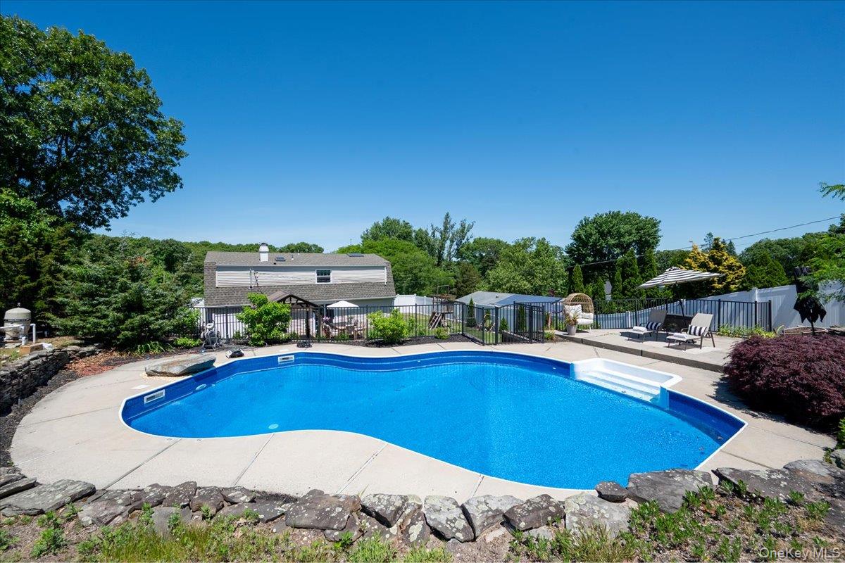 10 Rutgers Road Farmingville, NY 11738 - Photo 27 of 27 a view of a swimming pool with an outdoor seating and a yard