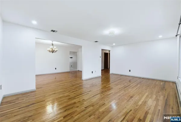 a view of a room with wooden floor and ceiling fan