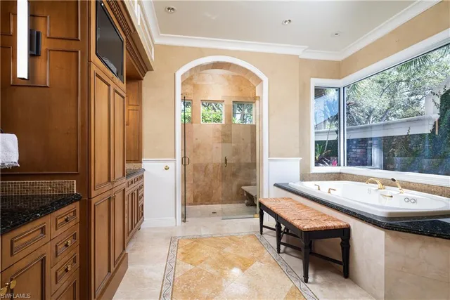a spacious bathroom with a tub a sink and a large window