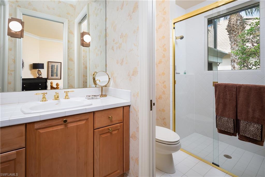 980 Barcarmil Way Naples, FL 34110 - Photo 23 of 50 a bathroom with a toilet a sink and a large mirror
