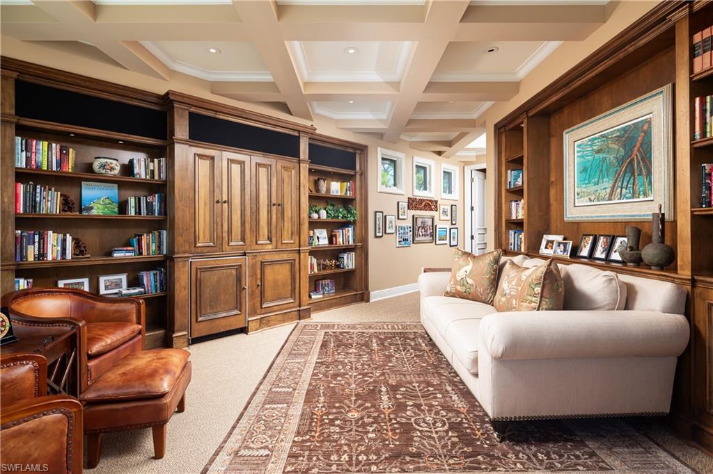 980 Barcarmil Way Naples, FL 34110 - Photo 25 of 50 a living room with furniture and a book shelf