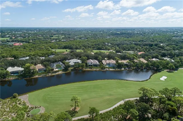 an aerial view of residential houses with outdoor space and lake view