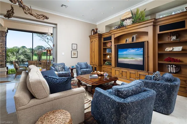 a living room with furniture a flat screen tv and a floor to ceiling window